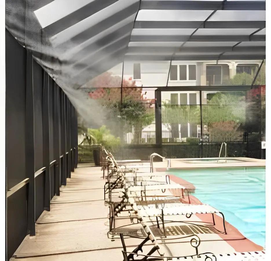 Outdoor poolside cooling setup featuring a MistCooling system with misting fans, nozzles, and a misting pump, ensuring comfort for apartment residents near the swimming pool.